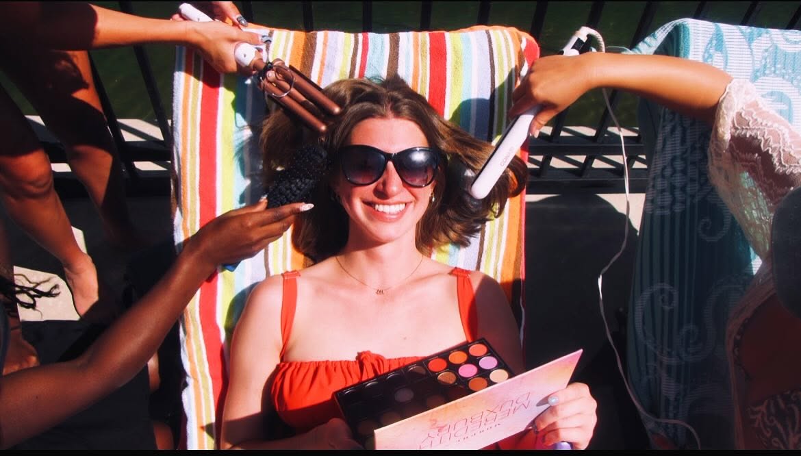 Model smiling during poolside hair and makeup styling